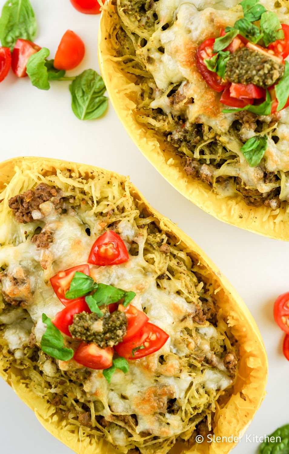 Pesto Spaghetti Squash in a hollow squash with tomatoes and basil.