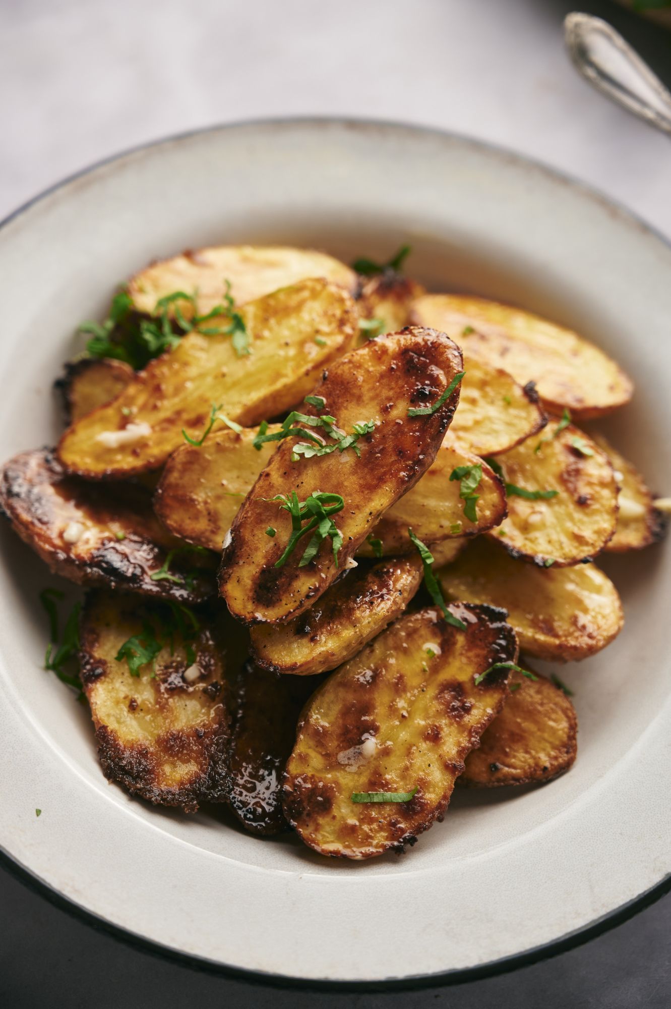 Fingerling potatoes roasted with olive oil and spices with crispy browned edges served with parsley.