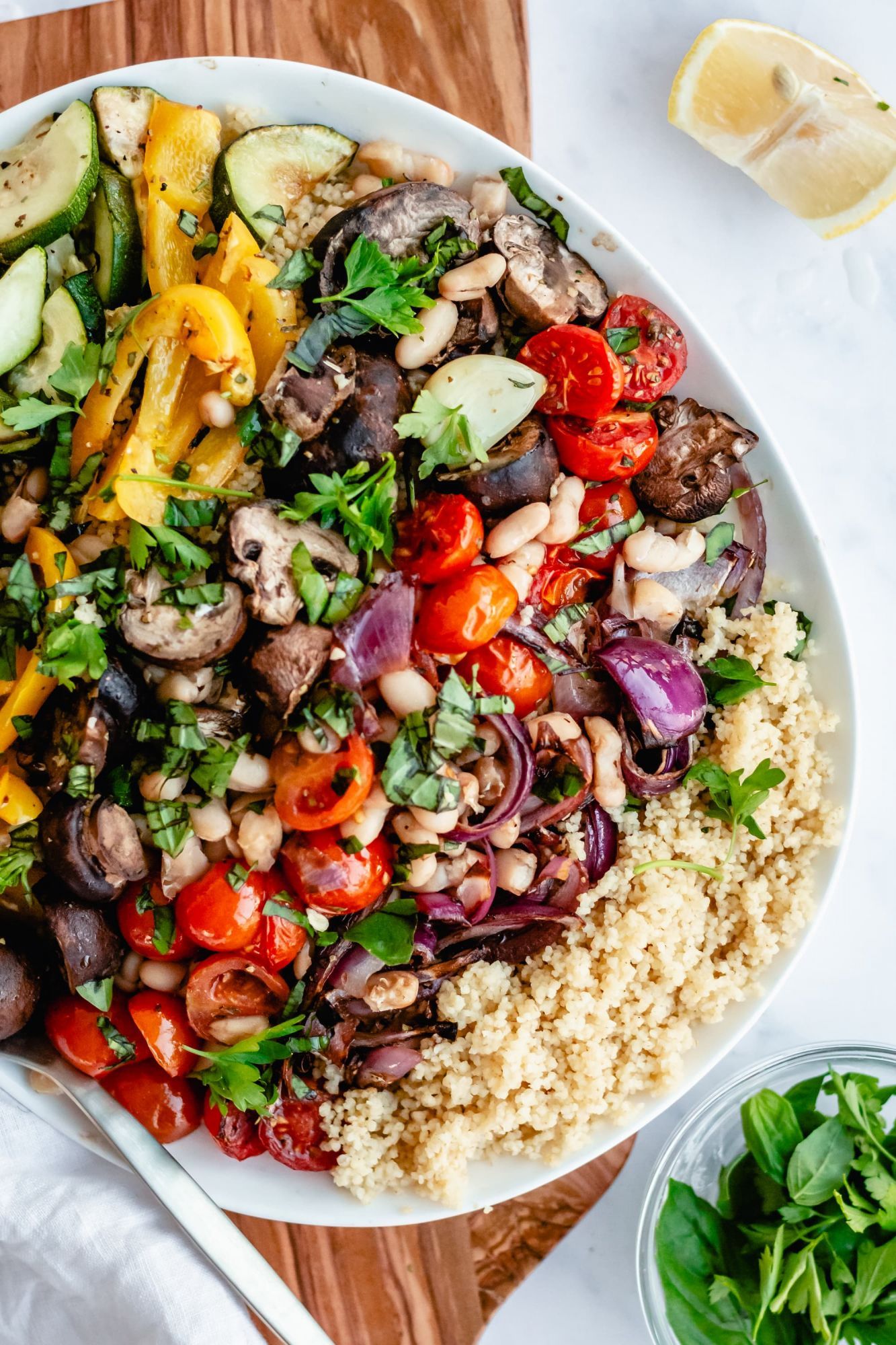Couscous with roasted vegetables including mushrooms, zucchini, bell peppers, and onions with olive oil, fresh herbs, and vinegar.