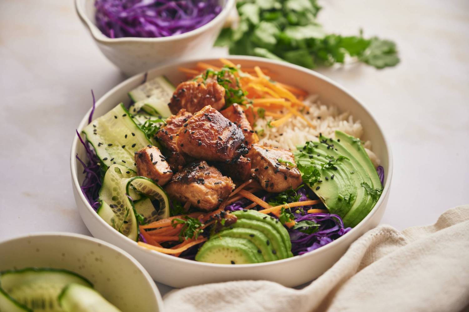 Salmon rice bowl with crispy salmon, white rice, avocado, and vegetables.