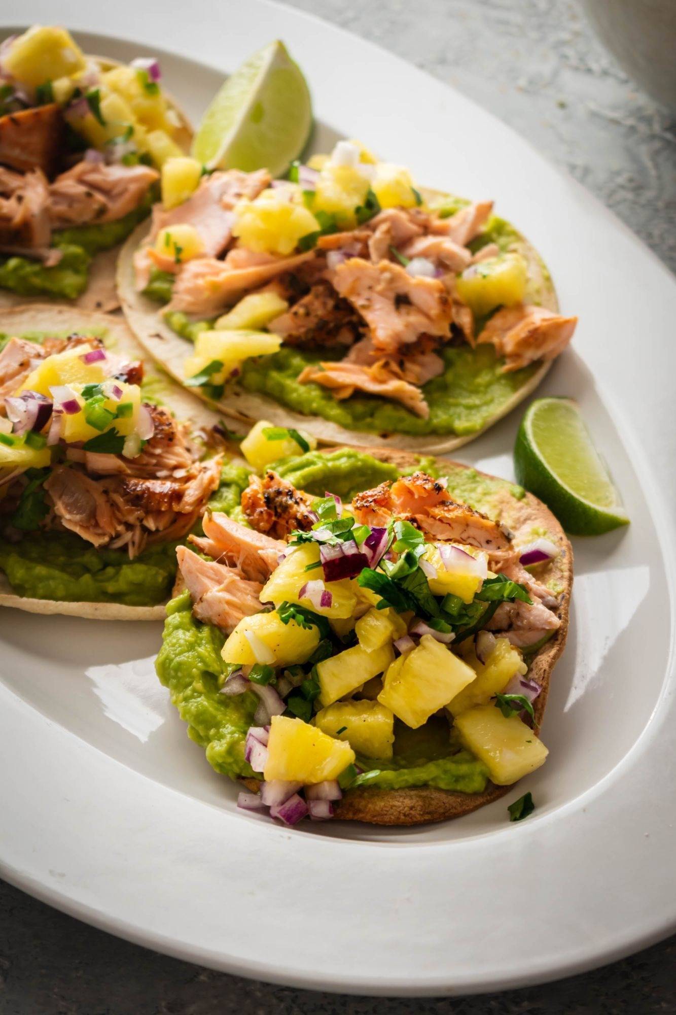 Mexican salmon Tostadas are served on tortillas with spice-coated salmon on avocado and pineapple salsa.