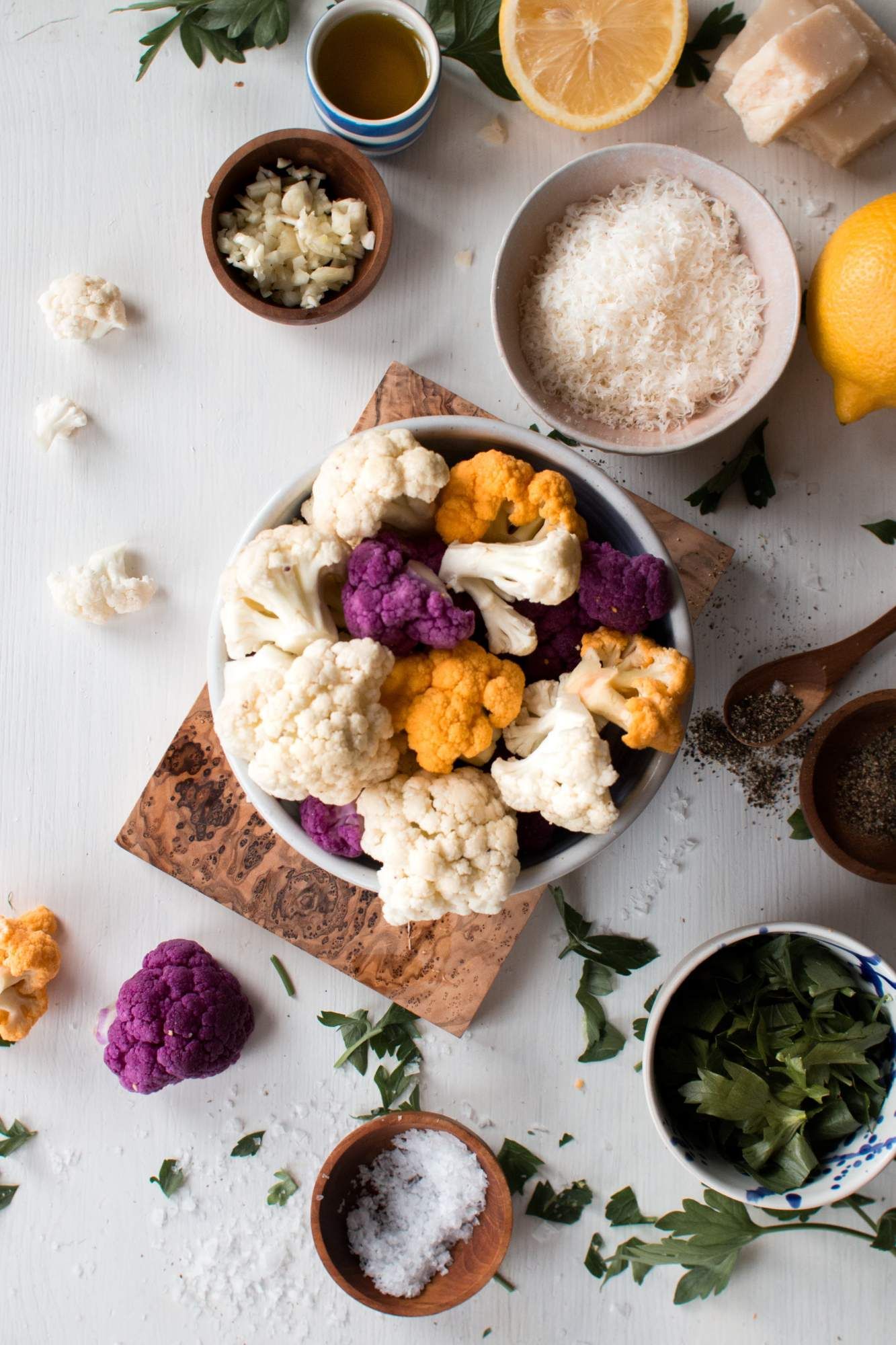 Ingredients for Sauteed Cauliflower including caulfilower florets, olive oil, minced garlic, parsley, lemon, and Parmesan cheese.