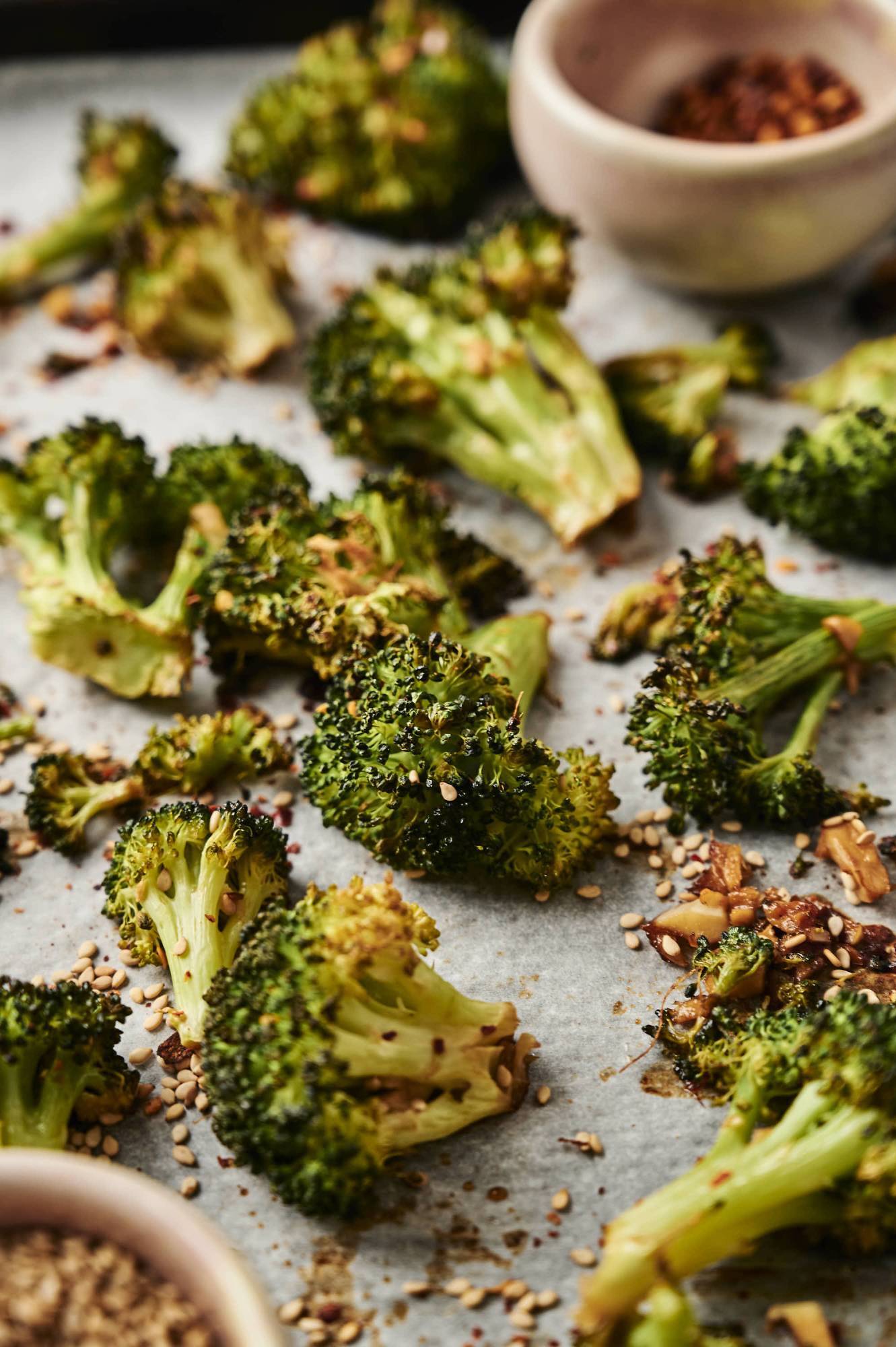 Roasted sesame broccoli with sesame seeds on a baking sheet.