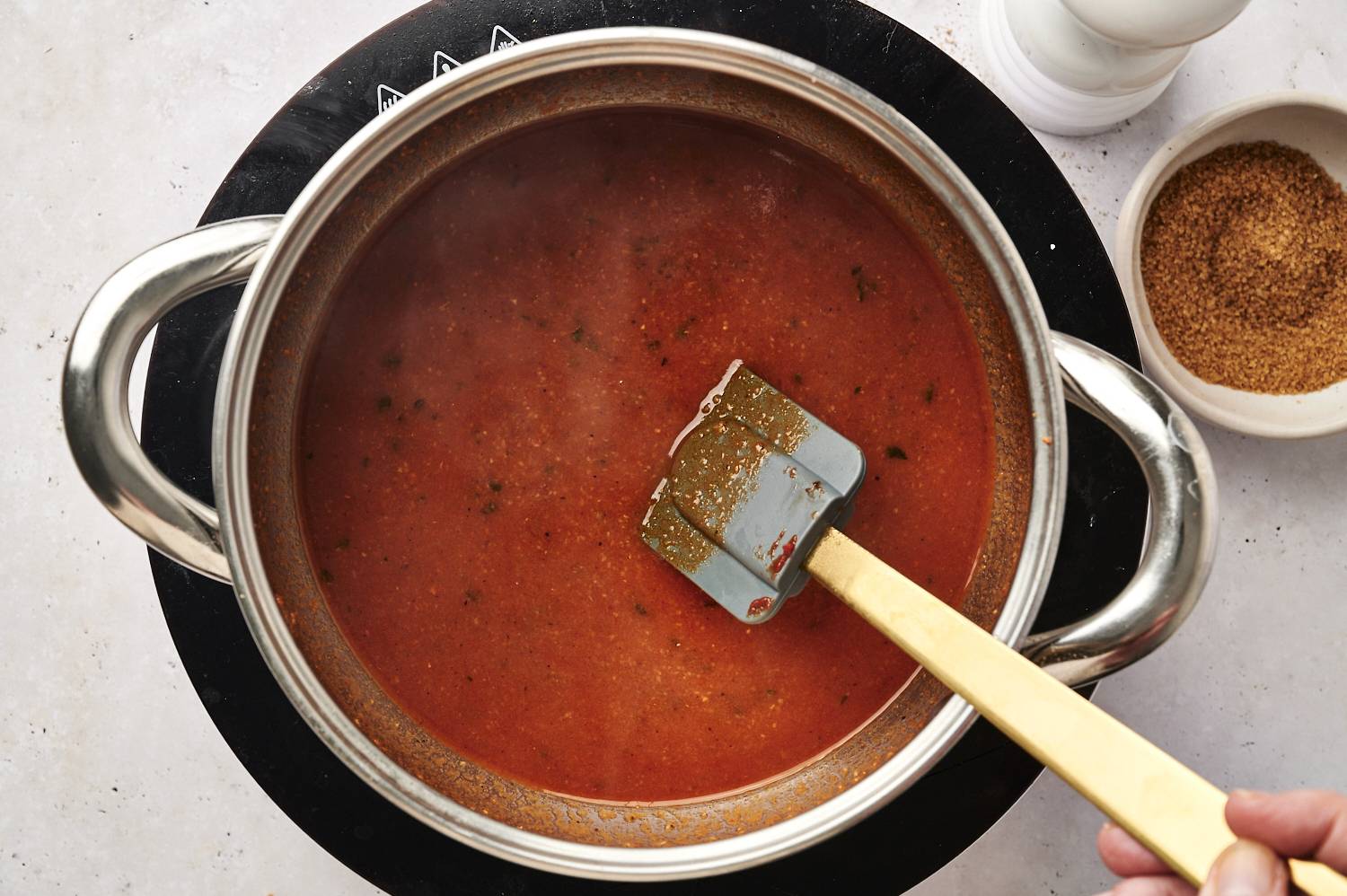 Red enchilada sauce in a pot with spices.