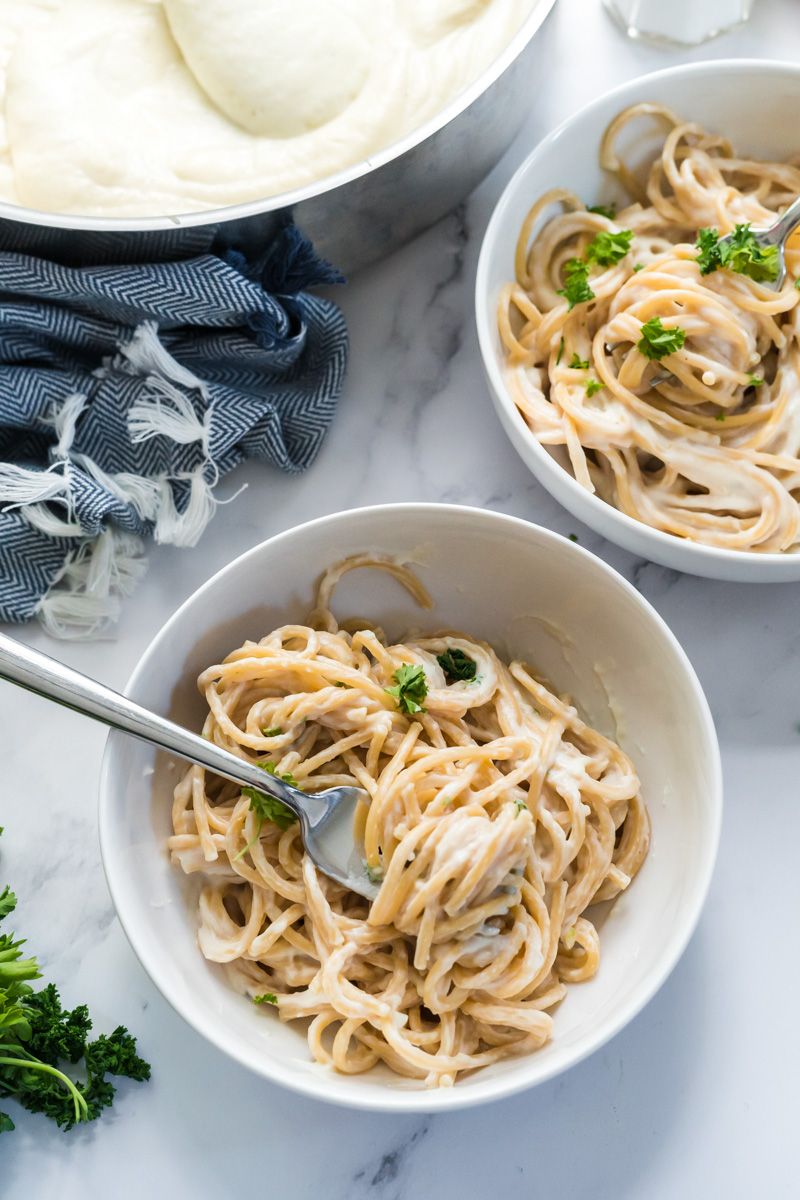 Healthier alfredo sauce made with cauliflower in a pan with spaghetti on the side.