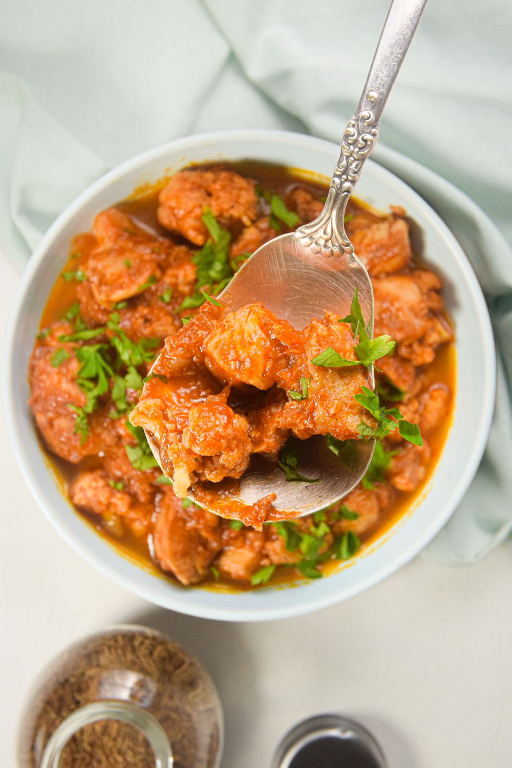 Crockpot chicken tikka masala with cauliflower in a dish with a creamy tomato sauce.