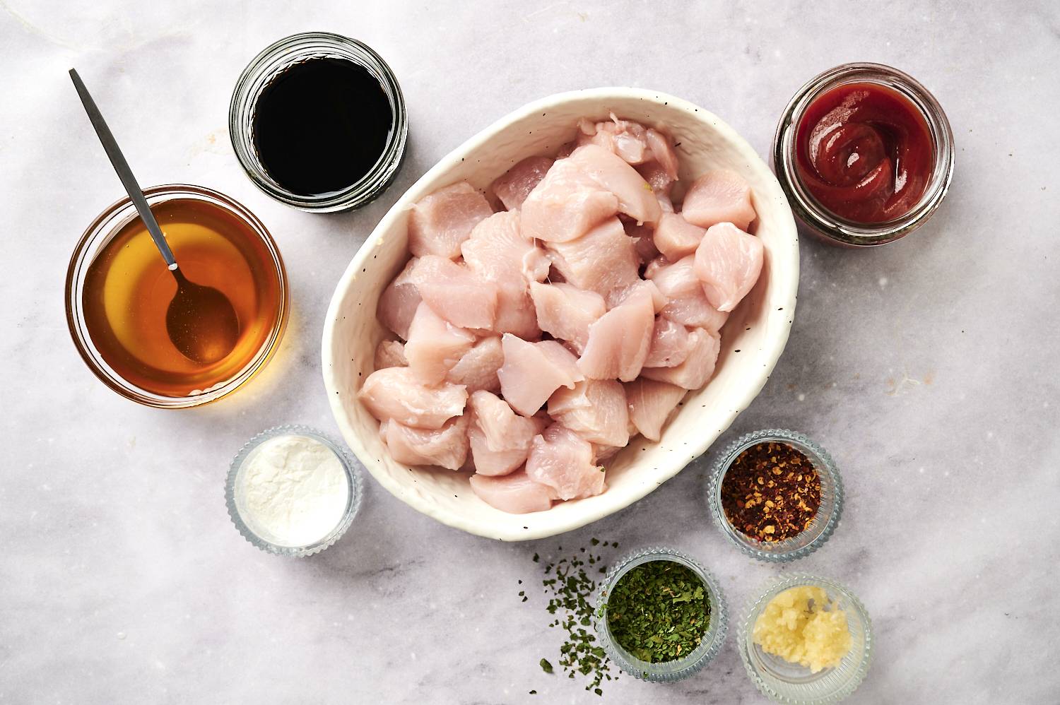 Ingredients for crockpot honey garlic chicken including chicken breast, honey, soy sauce, garlic, tomato paste, cornstarch, and red pepper flakes.