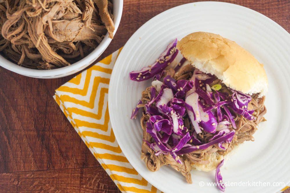 Crockpot Korean pork served in a sandwich roll with red cabbage.