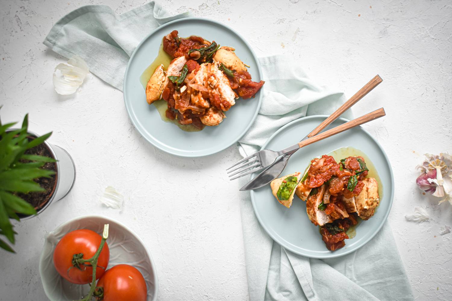 Overhead shot of two plates with tomato balsamic chicken on.
