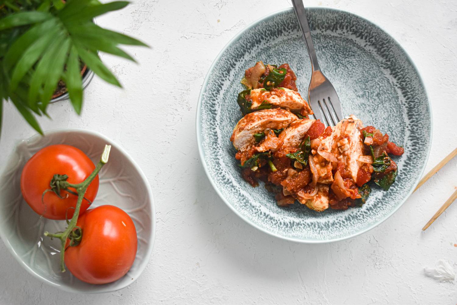 Balsamic chicken on a plate, with fork and knife off to the side.