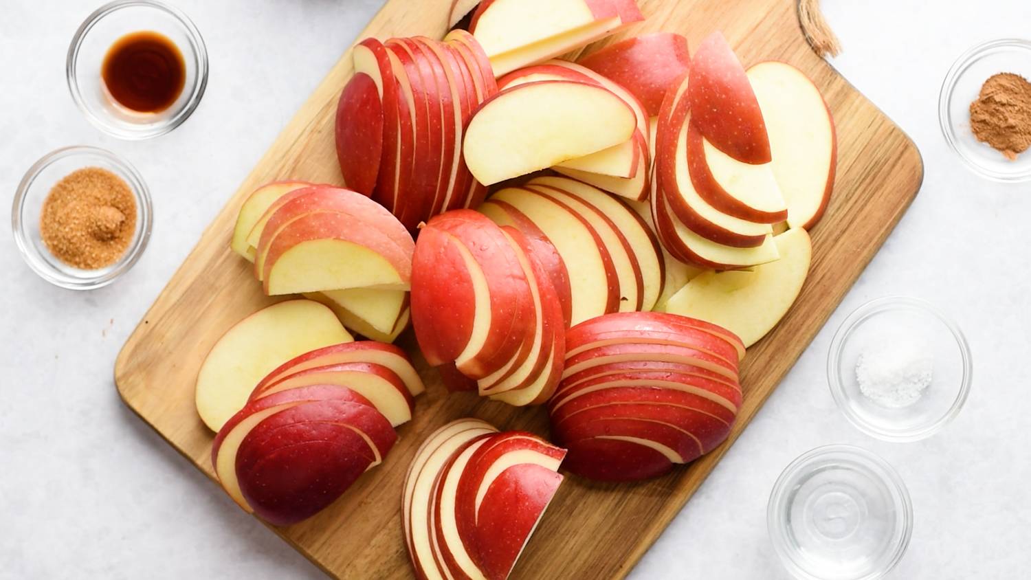 Ingredients to make cinnamon apples laid out, including sliced apples and spices.