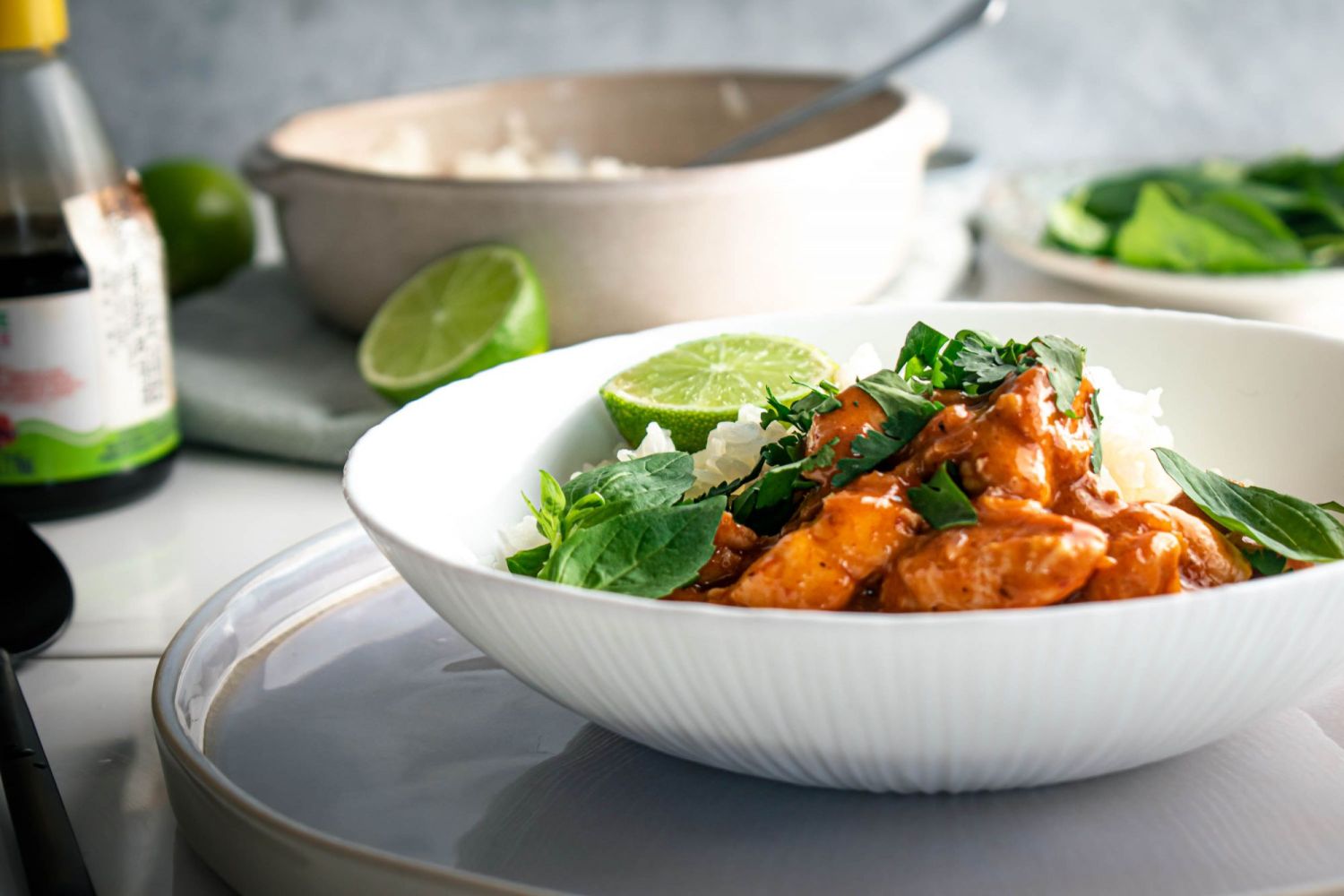 Creamy Thai red curried chicken breast served in a bowl with white rice and fresh herbs,