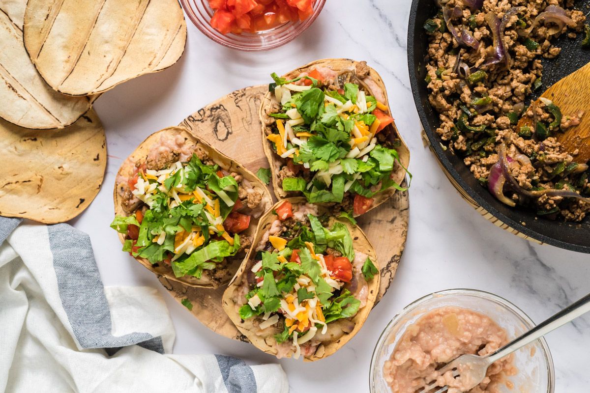 Grond turkey and poblano tostadas with lettuce, tomatoes, shredded cheese, and corn tortillas.