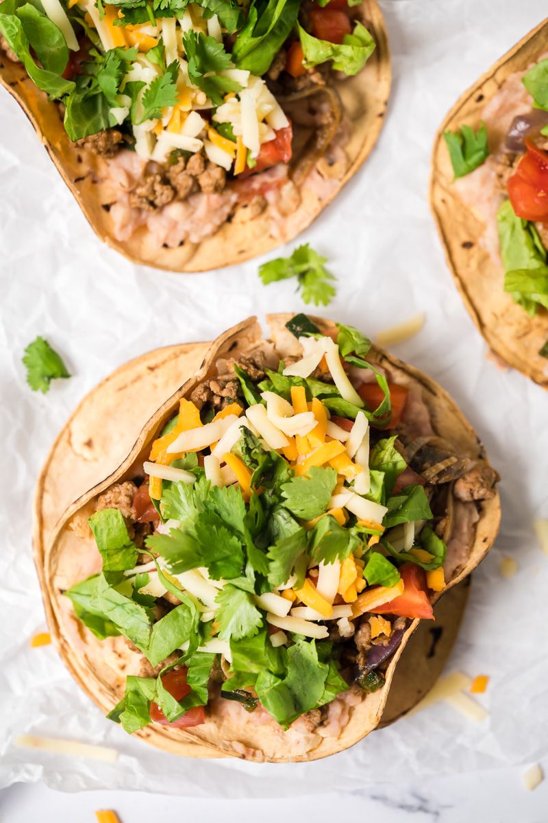 Turkey and bean tostadas with poblano peppers served on baked tostada shells and served with lettuce, tomatoes, cilantro, and cheese.