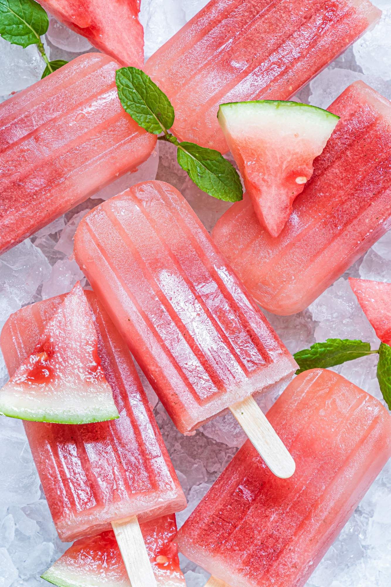 Homemade watermelon popsicles made with fresh watermelon and honey on ice with fresh mint.