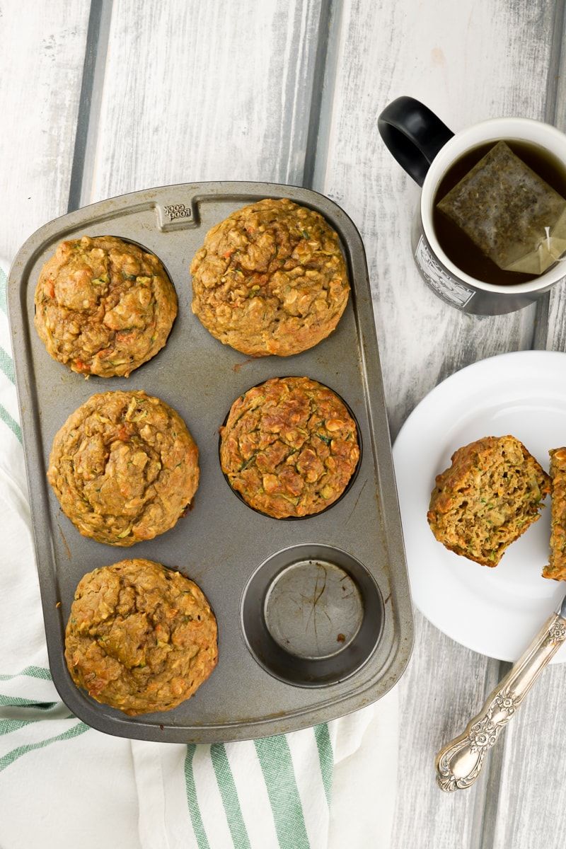 Zucchini Carrot muffins in a muffin tin with a fork.