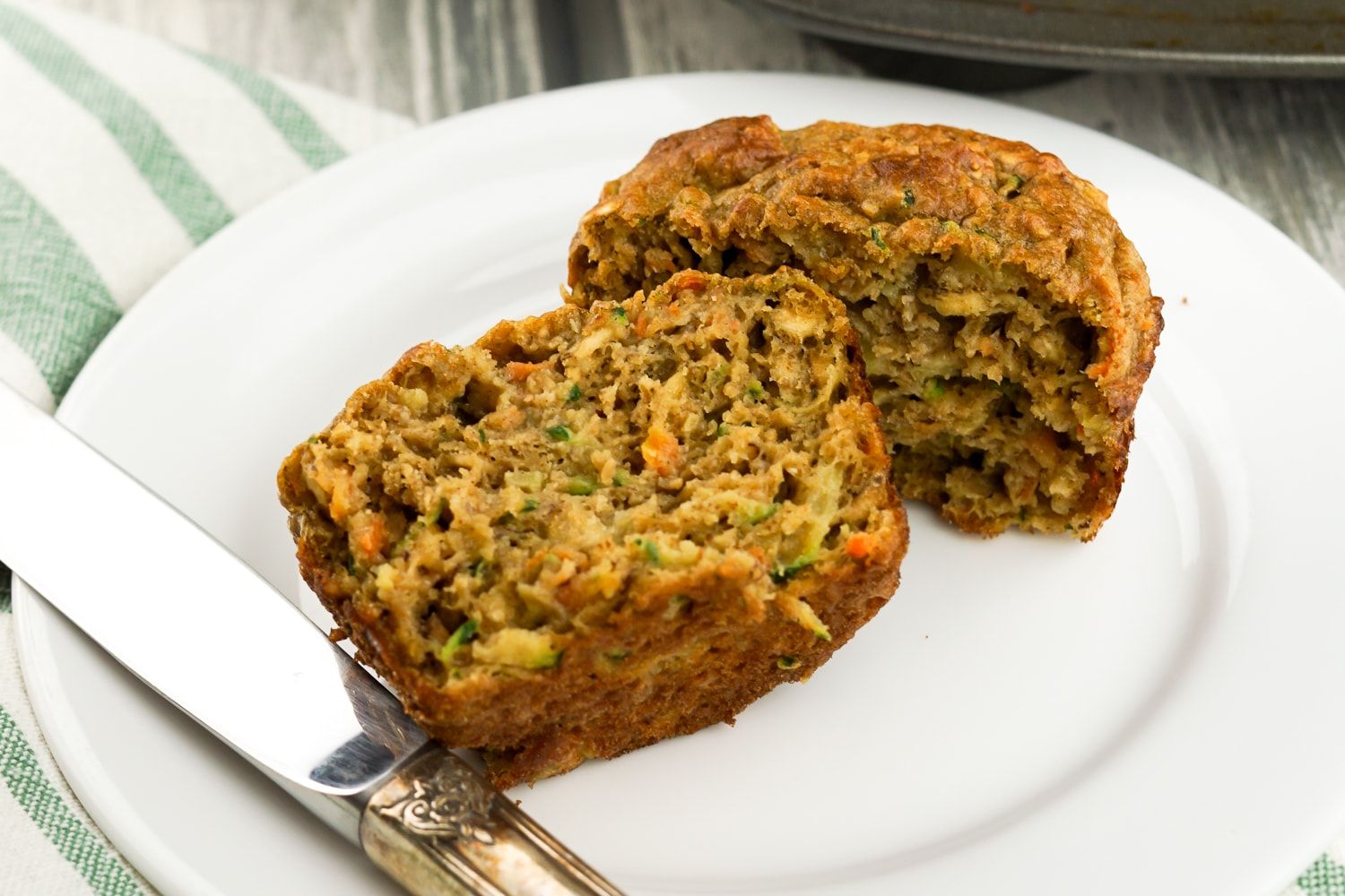 Healthy Zucchini Carrot Muffins in a muffin tin with a cup of tea.