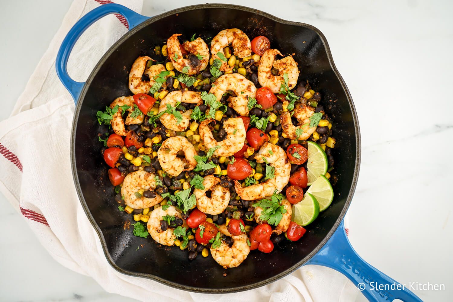 Mexican shrimp skillet with tomatoes, corn, black beans, and cilantro in a skillet.