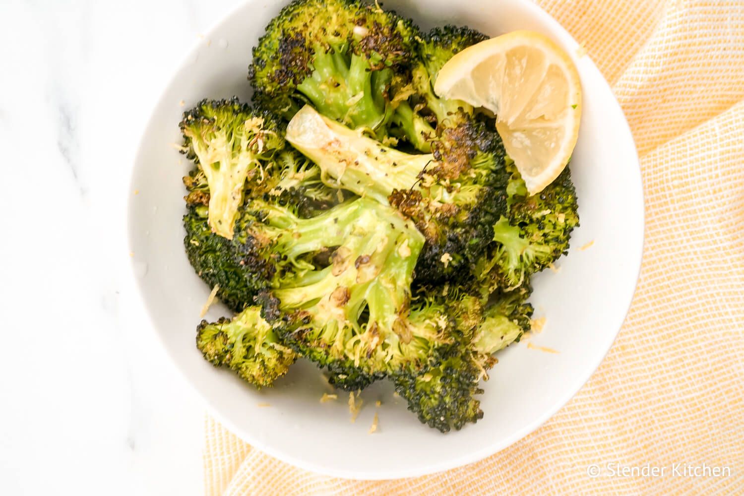 Roasted broccoli with garlic and lemon in a bowl.