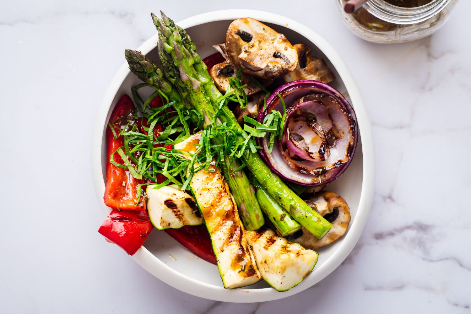 Grilled marinated vegetables including zucchini, red onion, mushroom, and asparagus.