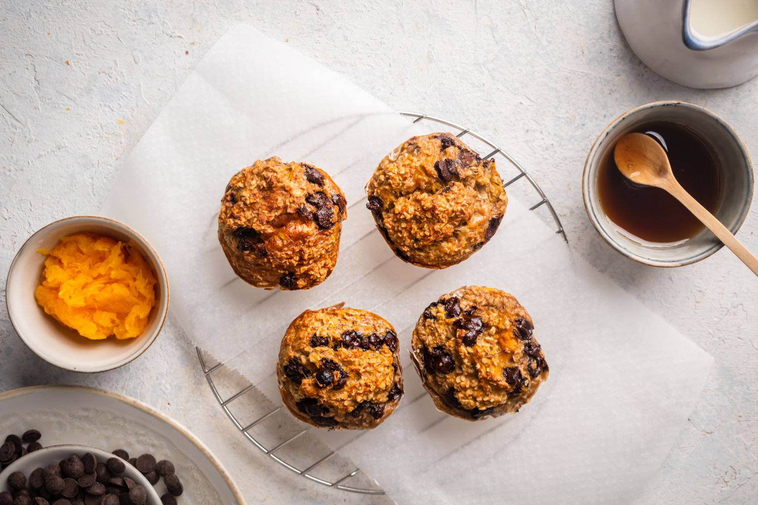 Pumpkin oatmeal muffins with chocolate chips on a marble board.