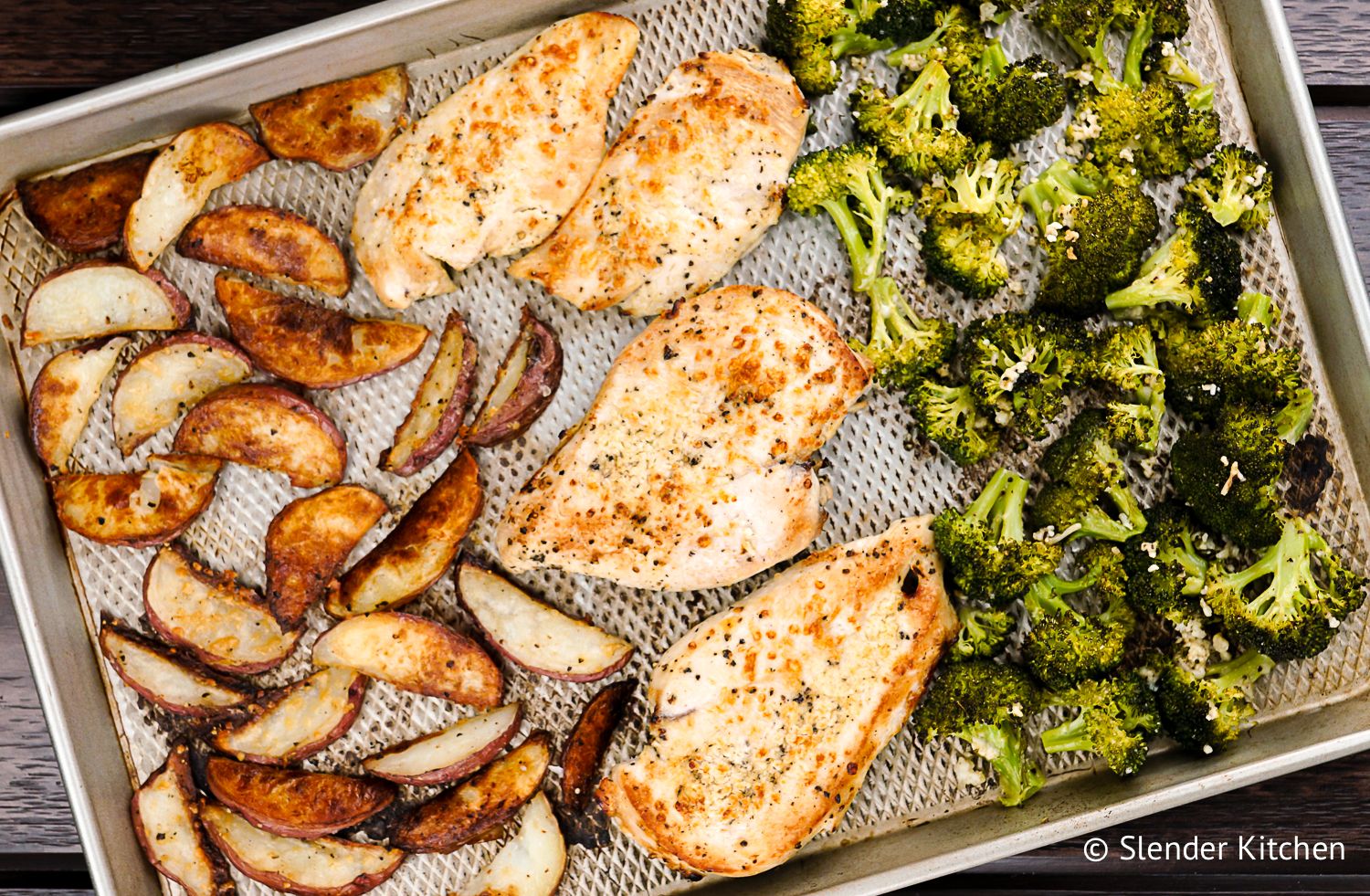 Roasted broccoli, potatoes, and chicken on a sheet pan.