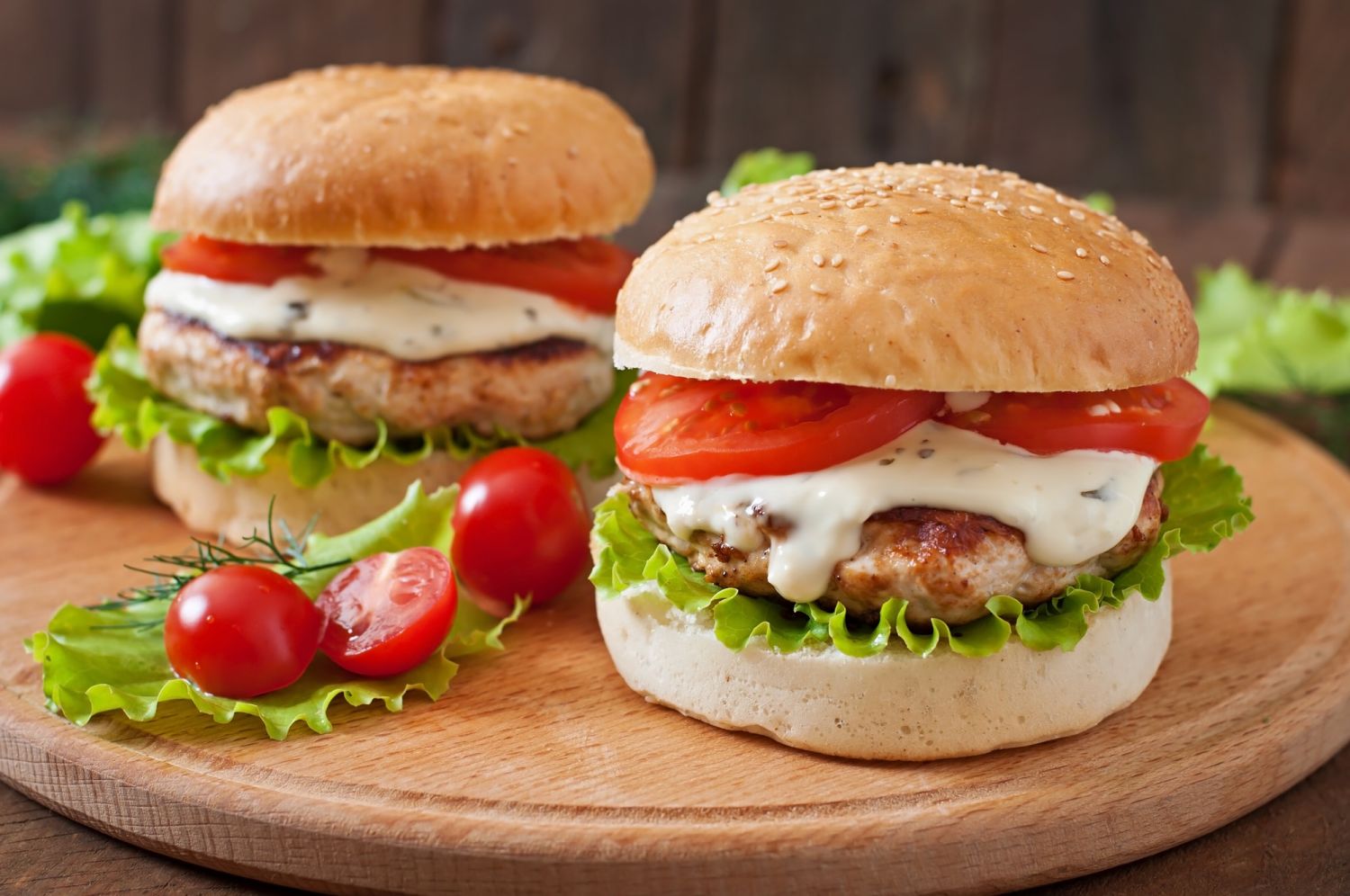 Healthy turkey burgers on a wooden cutting board.