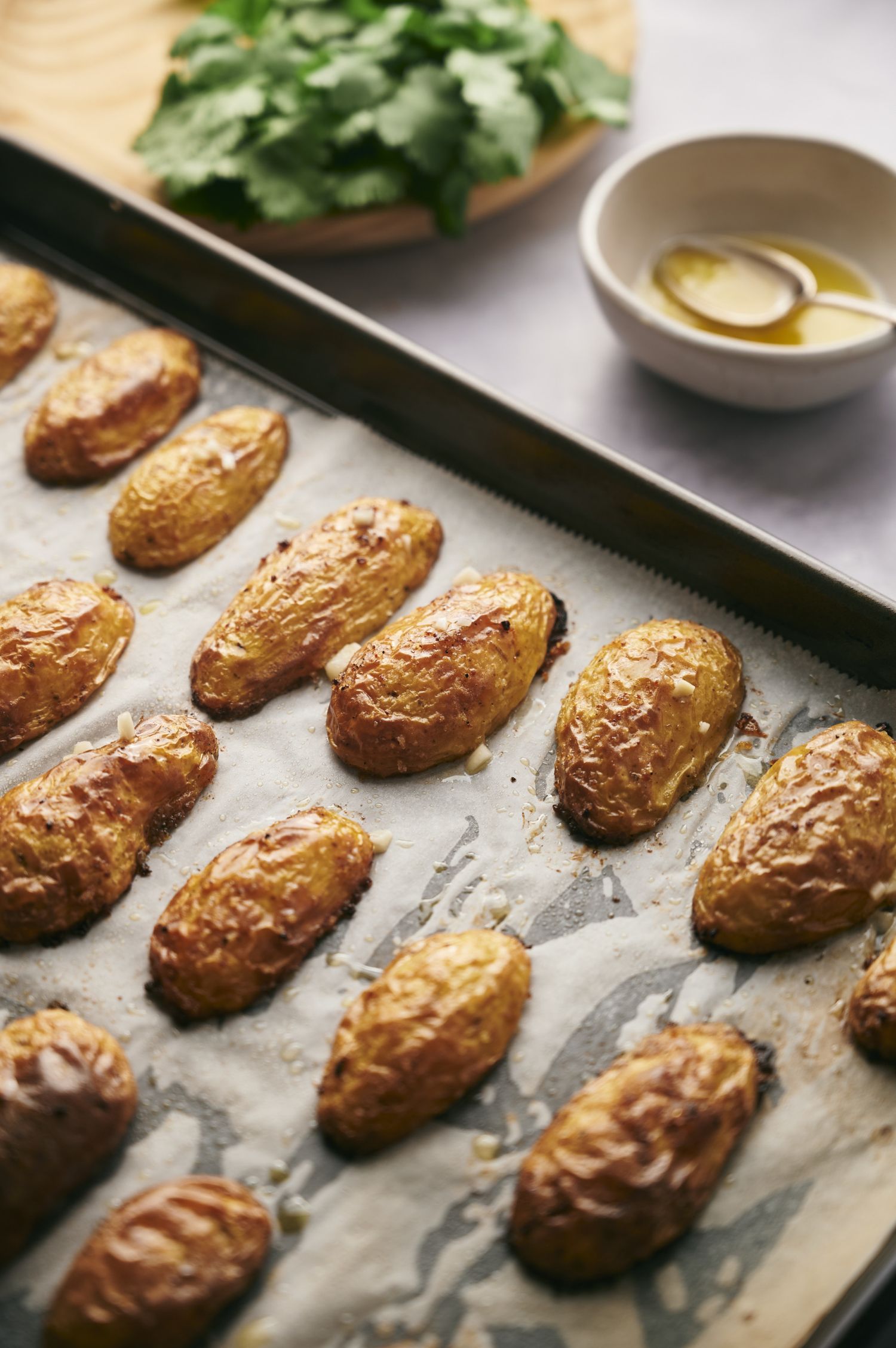 Baking sheet with fingerling potatoes that are roasted with olive oil and spices.
