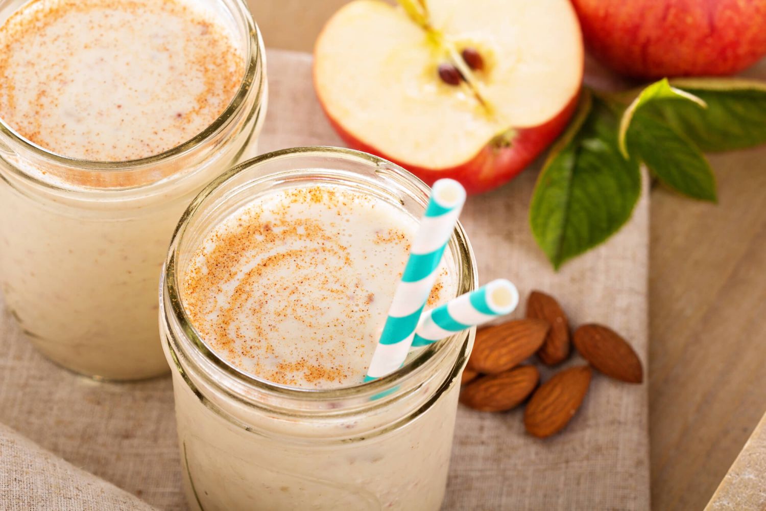 Apple Pie Smoothie in a mason jar with apples and almonds.