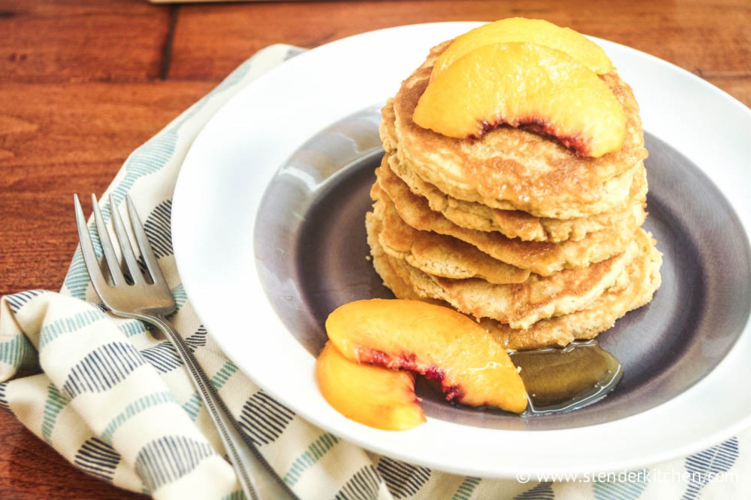 Low carb coconut pancakes on a plate with sliced peaches.