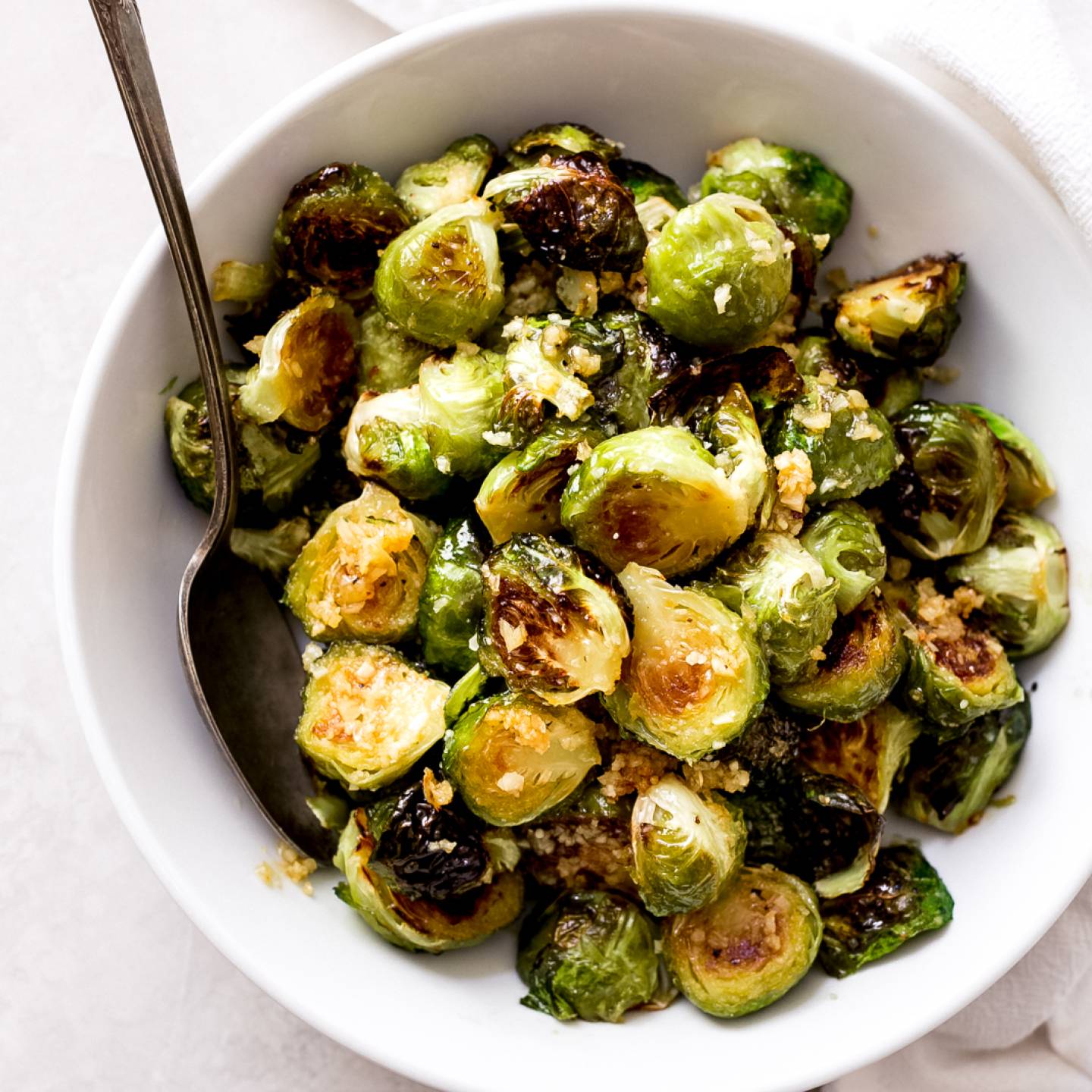 Honey Garlic Butter Brussels Sprouts in a bowl with Parmesan cheese.