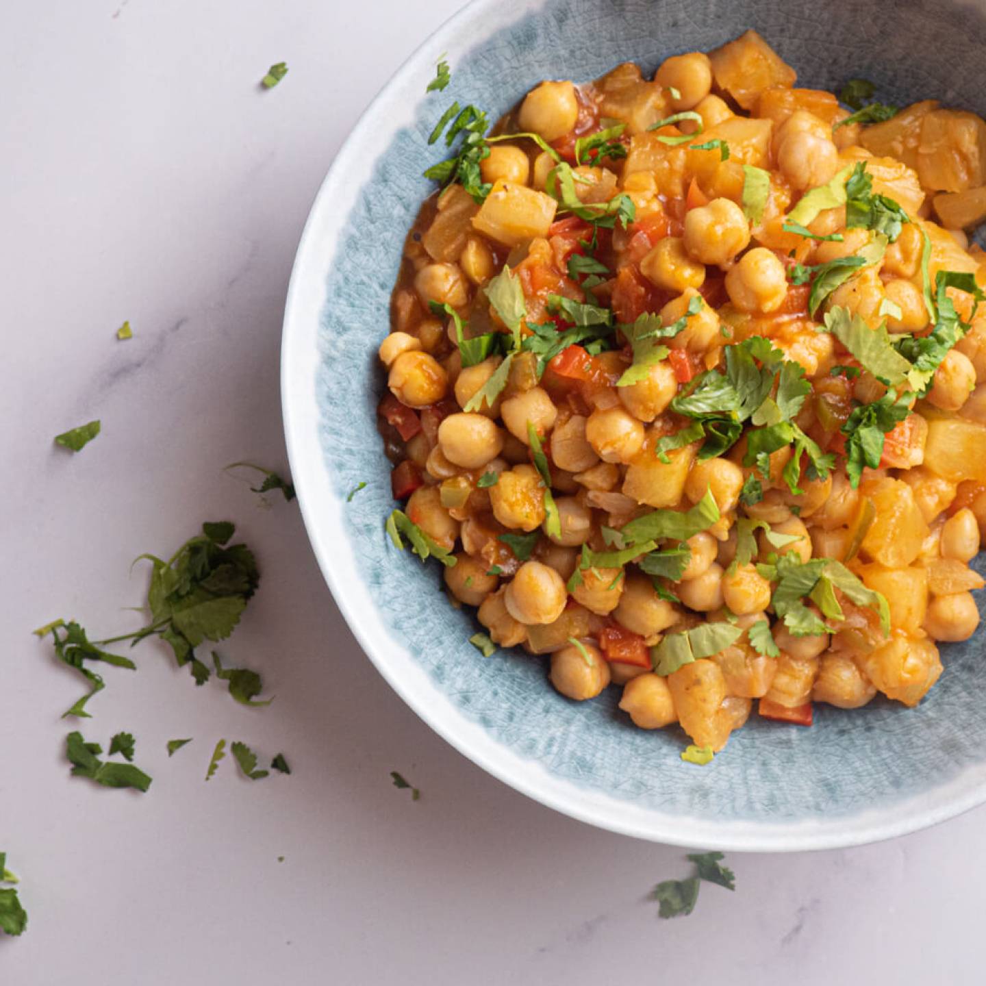 Slow cooker sweet and sour chickpeas with pineapple, red pepper, and cilantro in a bowl.
