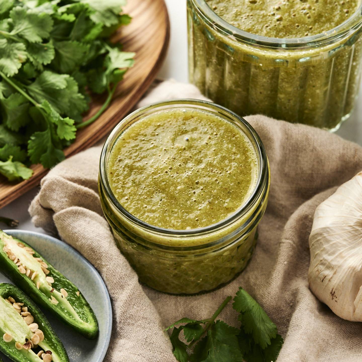 Authentic Green Enchilada Sauce Green enchilada sauce with tomatillos and jalapenos stored in a glass jar.