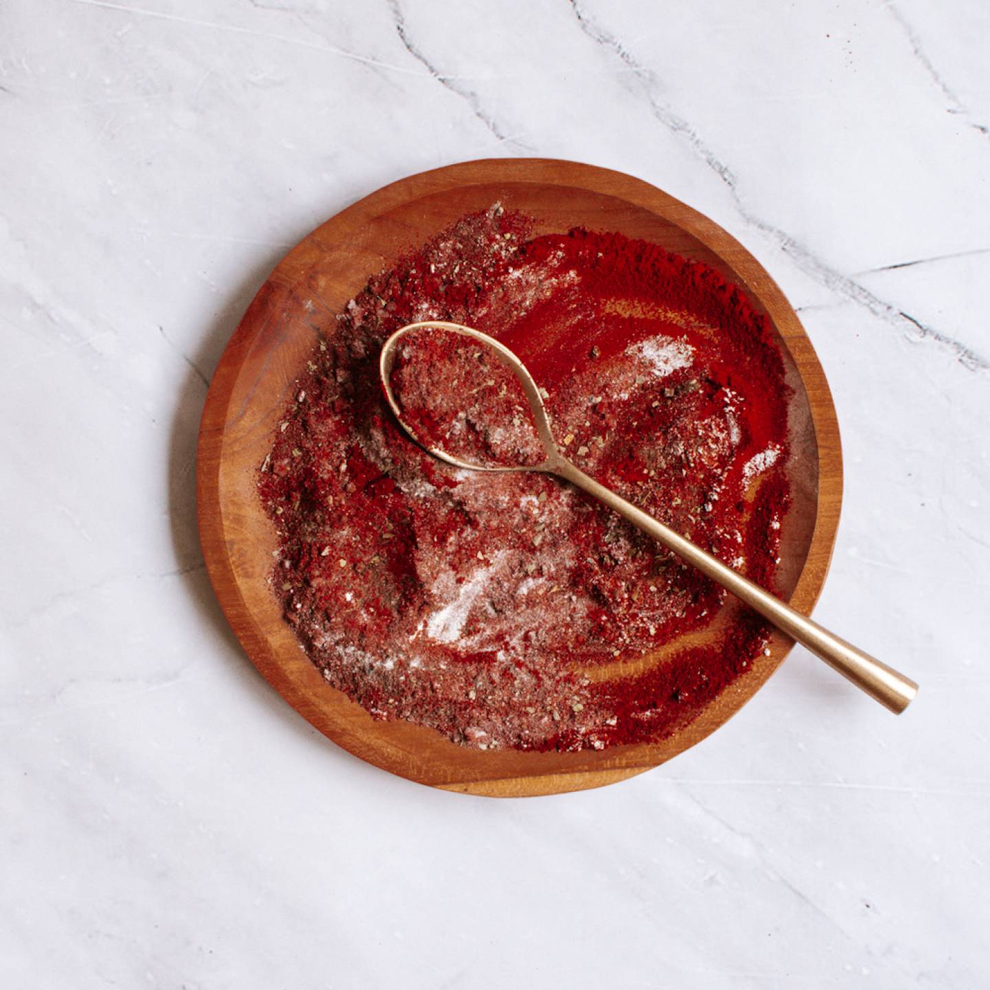 Blackening seasoning on a wooden plate with paprika, garlic powder, oregano, and more.