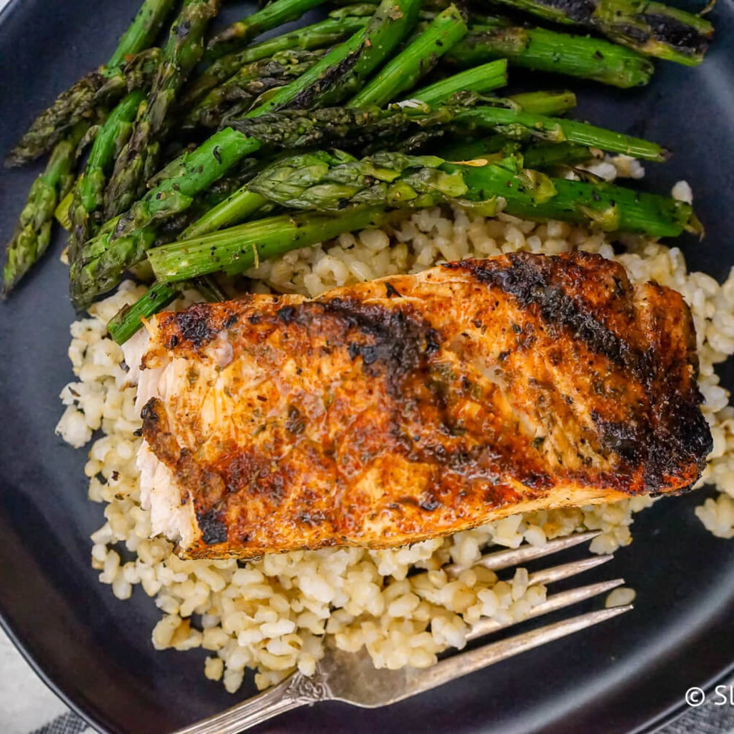 Cajun salmon on a bed of quinoa with asparagus.