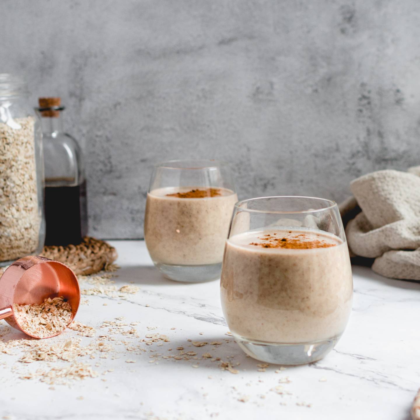 Creamy banana oatmeal smoothie with bananas, oats, almond milk, and almond butter blended and served in two glasses.