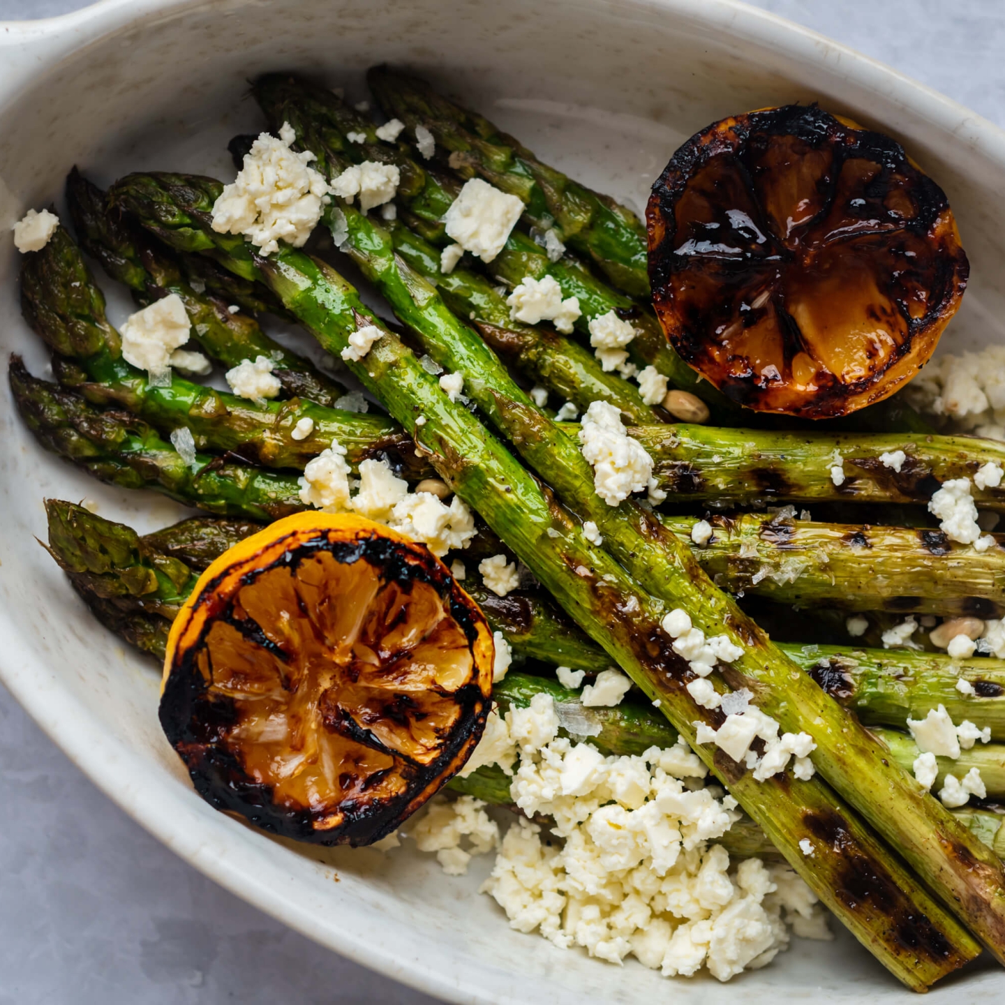 Grilled lemon asparagus topped with crumbled feta cheese and served with grilled lemon halves.
