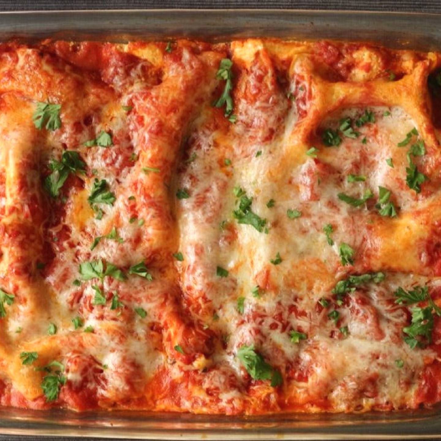 Healthy zucchini lasagna in a glass baking dish with melted cheese on top.