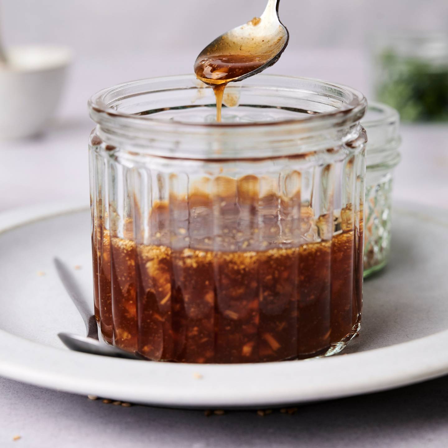Homemade teriyaki sauce in a jar with a spoon.