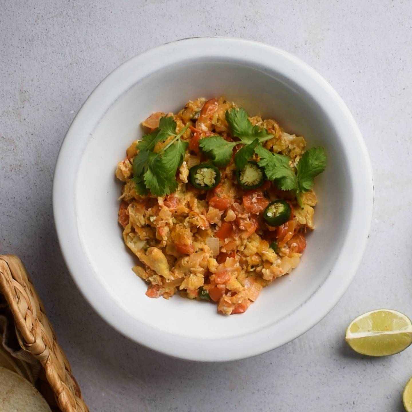 Huevos a la mexicana with scrambled eggs, tomatoes, onions, jalapenos, and cilantro in a bowl.