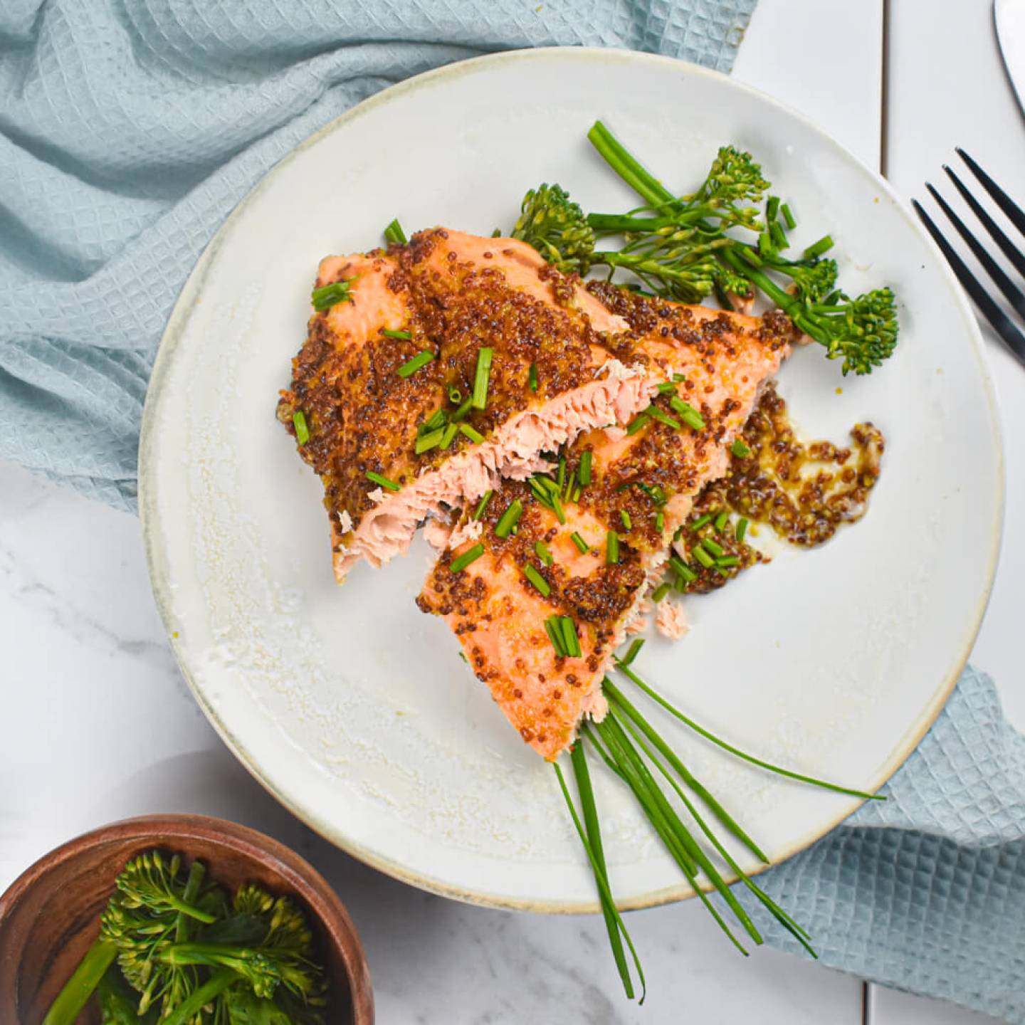 Mustard and maple glazed salmon with a honey mustard style sauce on a plate with broccolinl.