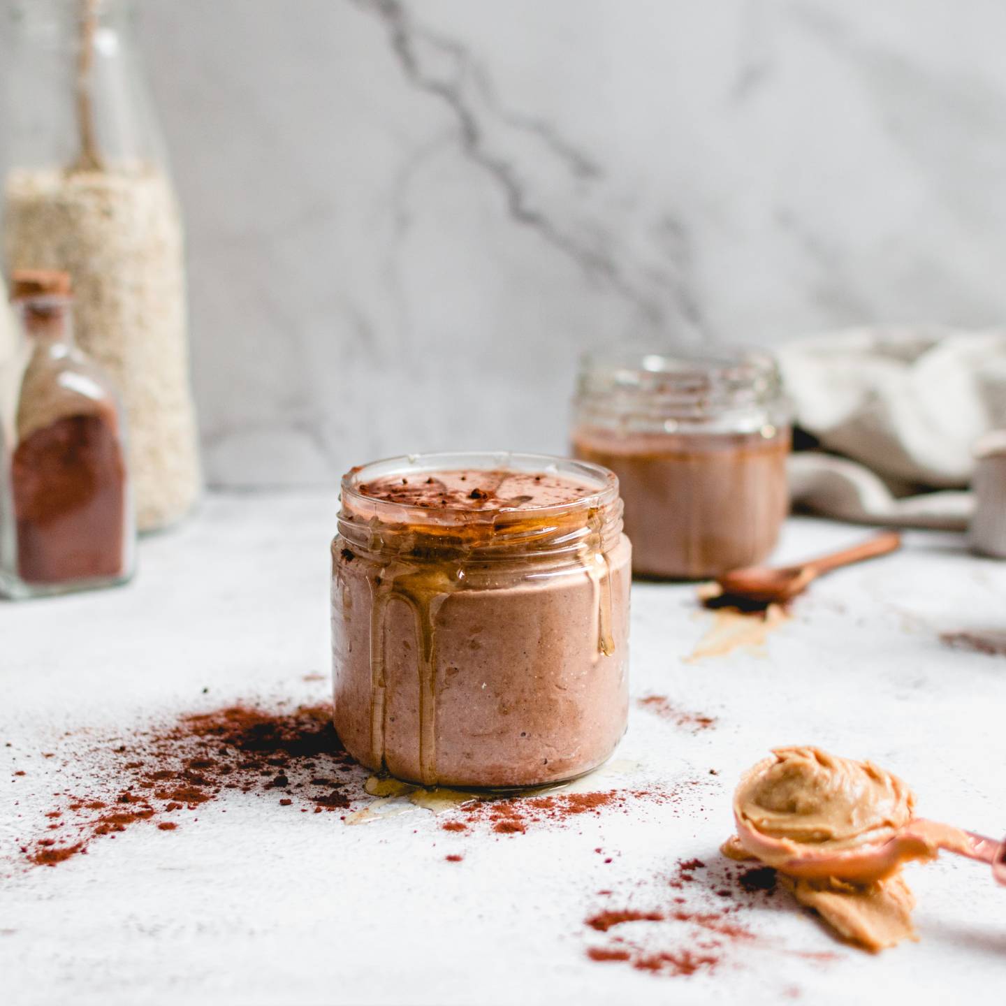 Peanut butter cup smoothie with bananas, oats, peanut butter, and cocoa powder blended and served in a glass.