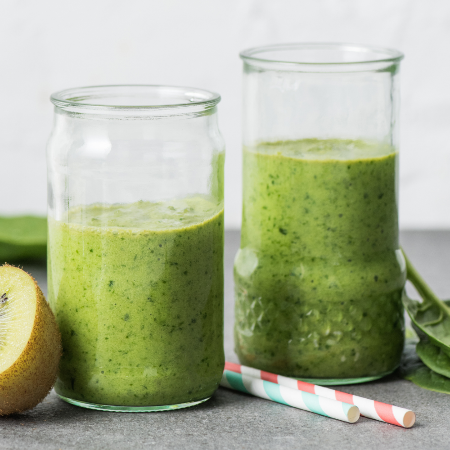 Pineapple cucumber smoothie with bananas, spinach, cucumber, and pineapple blended and served in two glasses.