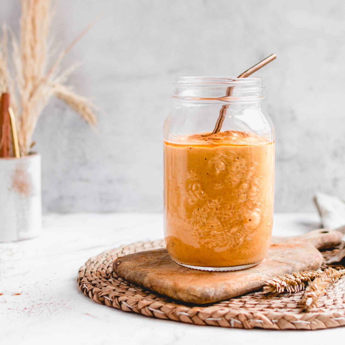 Pumpkin pie smoothie with canned pumpkin, pumpkin spice, almond milk, dates, and oats blended and served in a glass.