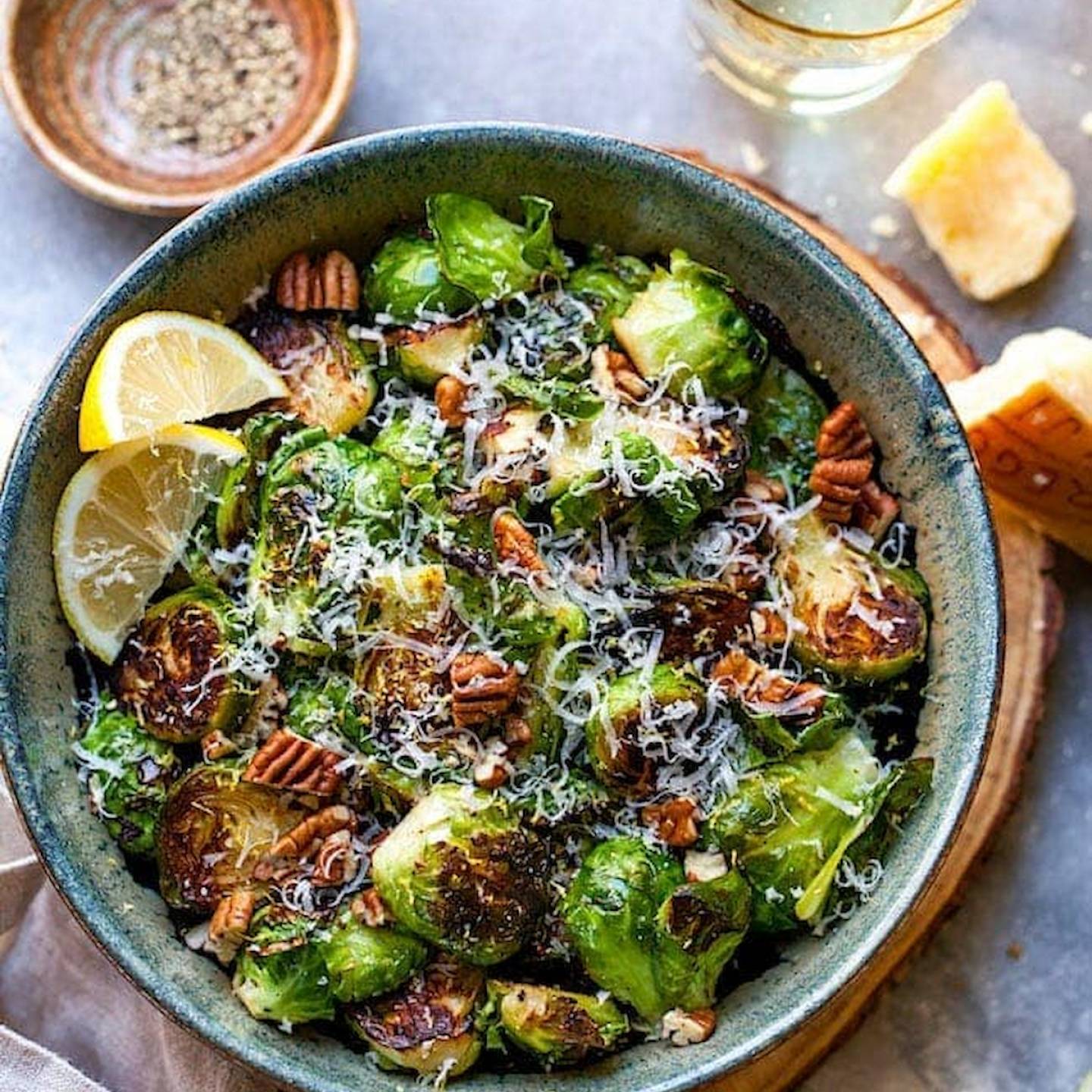 Sauteed Brussels sprouts in a bowl with lemon and Parmesan cheese.