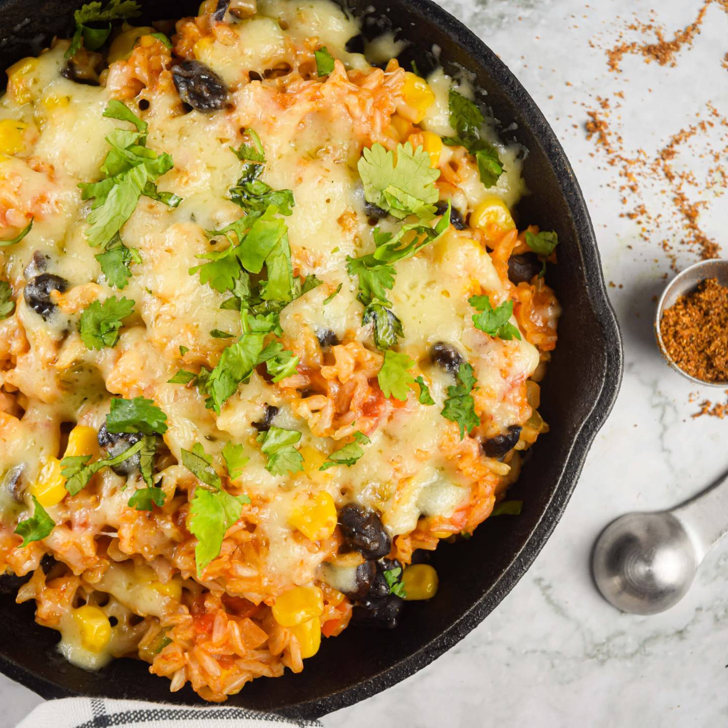 Mexican brown rice casserole with black beans, corn, tomatoes, bell peppers, and spices.