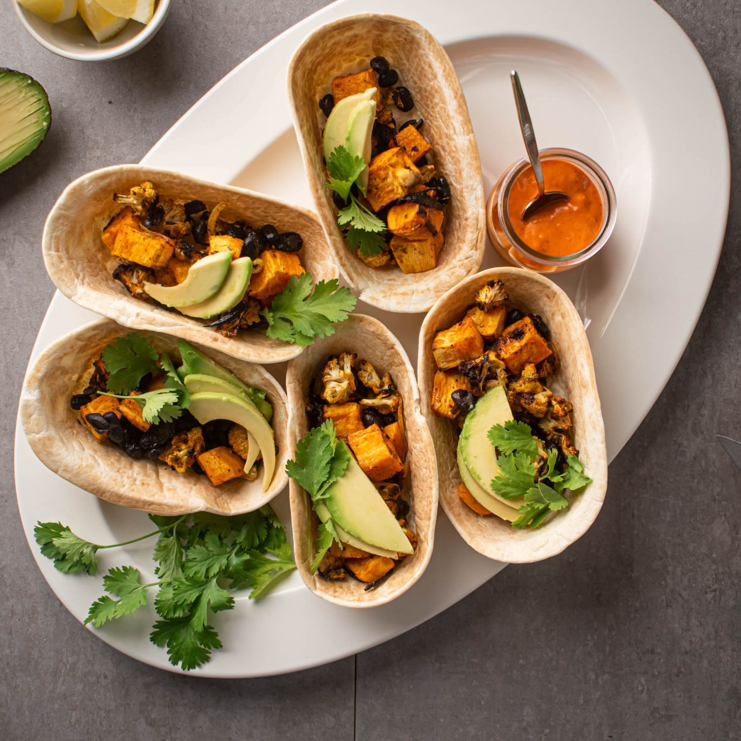 Sweet potato tacos with black beans, cauliflower, avocado, and cilantro served in corn tortillas. 