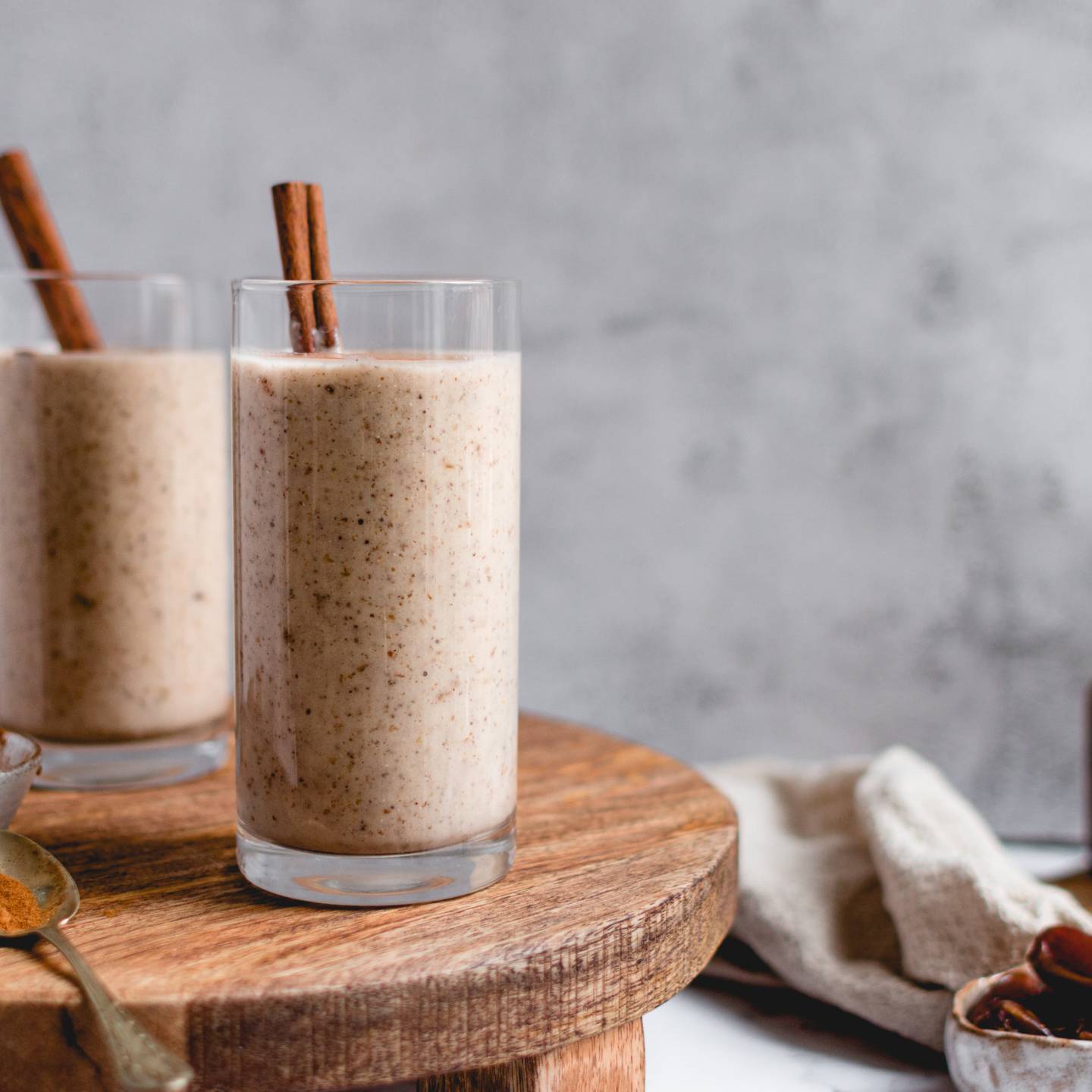 Vanilla cinnamon protein shake with bananas, cauliflower, protein, cinnamon, and almond butter poured in two glasses.