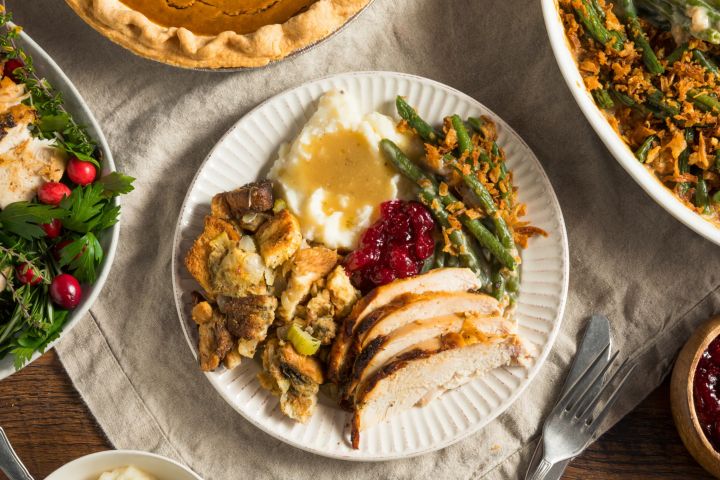 Healthy thanksgiving with roasted turkey, cranberry sauce, mashed potatoes, green beans, and stuffing.