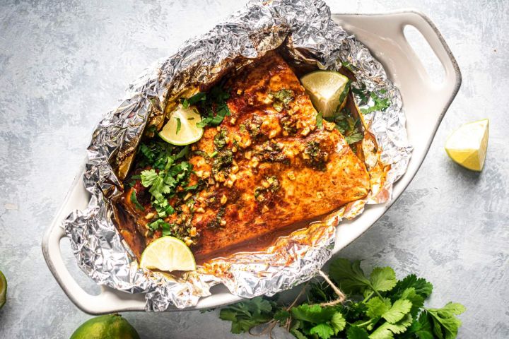 Whole30 Cilantro lime fish recipe with salmon, garlic, cilantro, butter, and limes.
